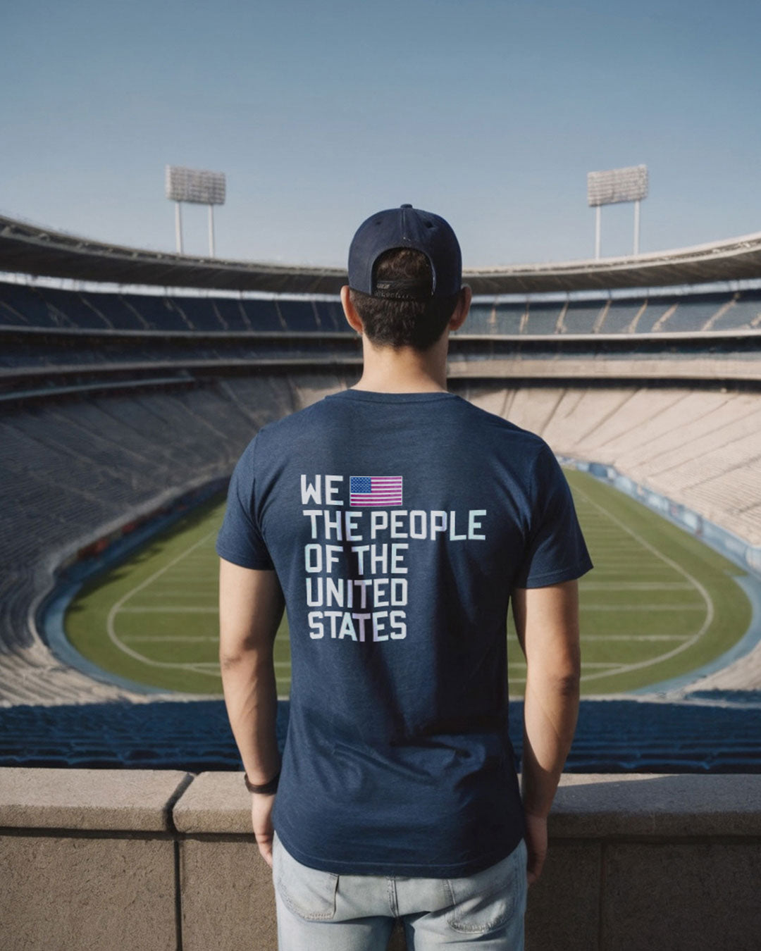 Man wearing the Navy t shirt "We the people of United States", standing in the stand of a soccer stadium 